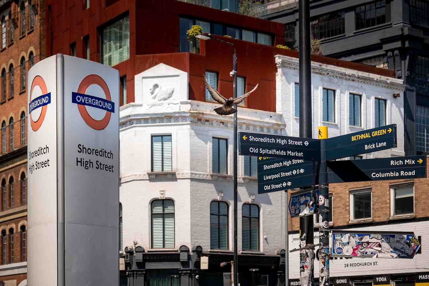 Shoreditch High Street overground station and directional sign post to local attraction in this trendy area of East London
