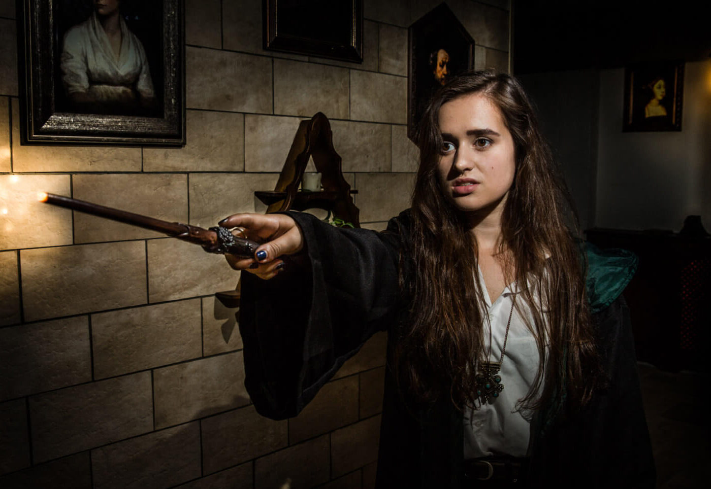 Witch holding out her wand in a magical escape room