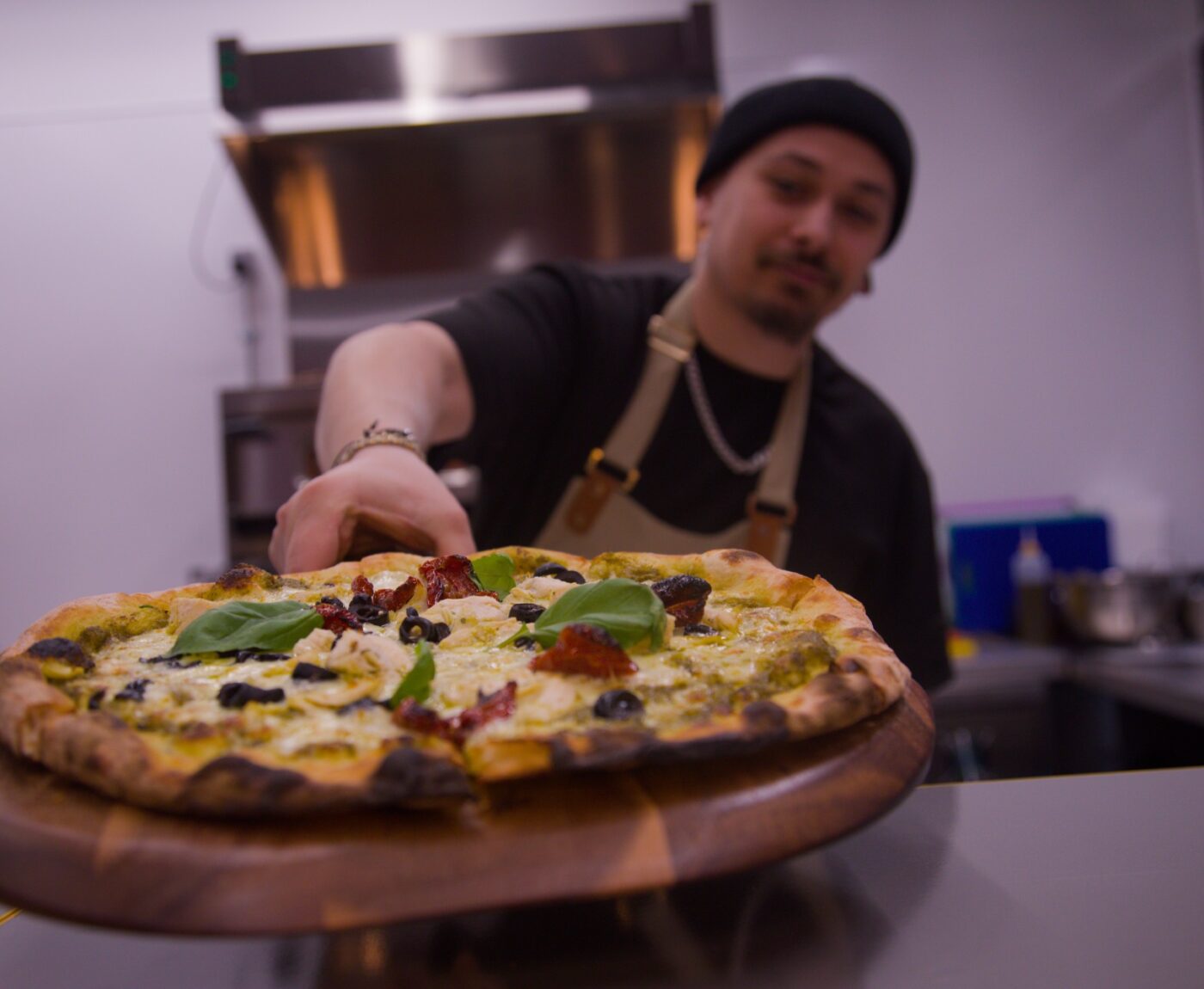 Chef holding a pizza from The Comet Club Enigma Quests