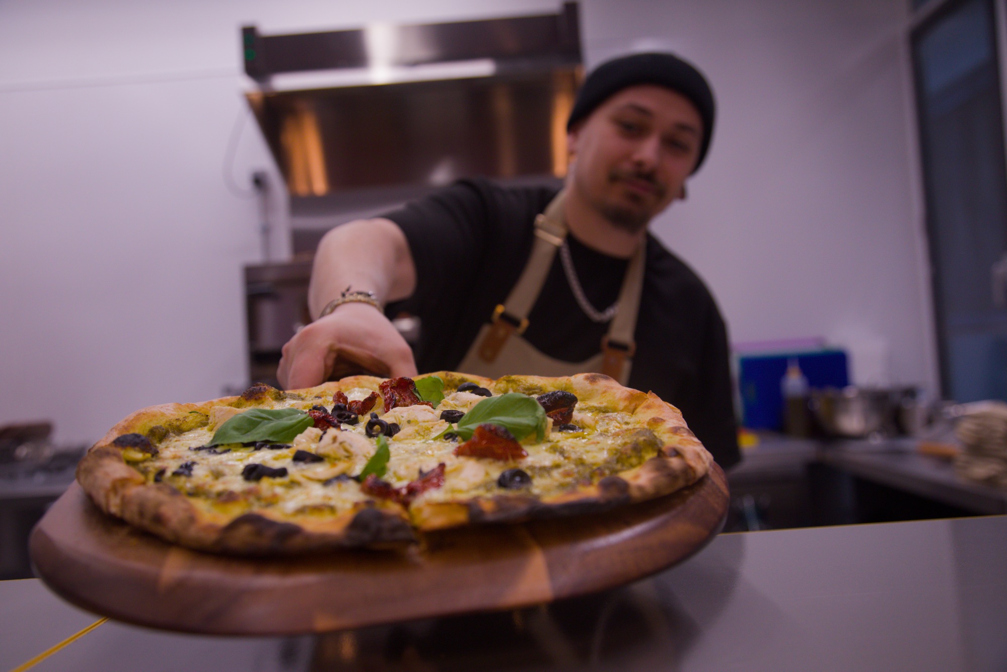 Chef holding a pizza from The Comet Club Enigma Quests